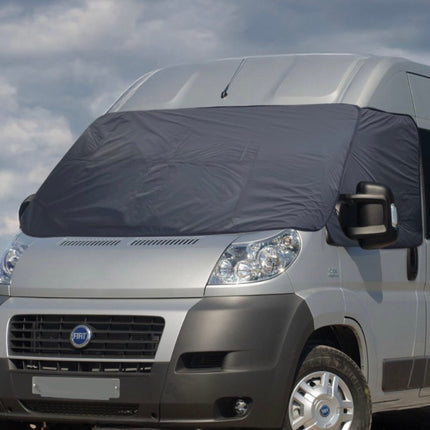 Gray van with a large windshield cover against a cloudy sky