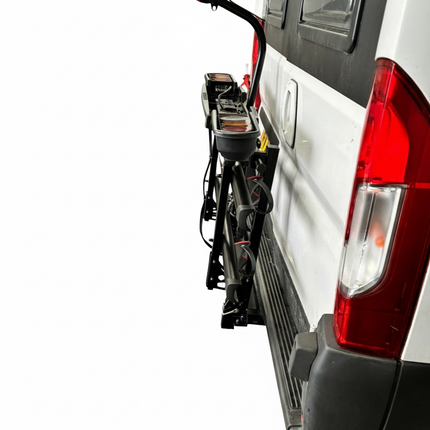 Bicycle rack attached to the back of a white van with Etang Auto Parts branding.