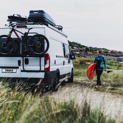 Van with bike rack and storage boxes in a scenic outdoor setting